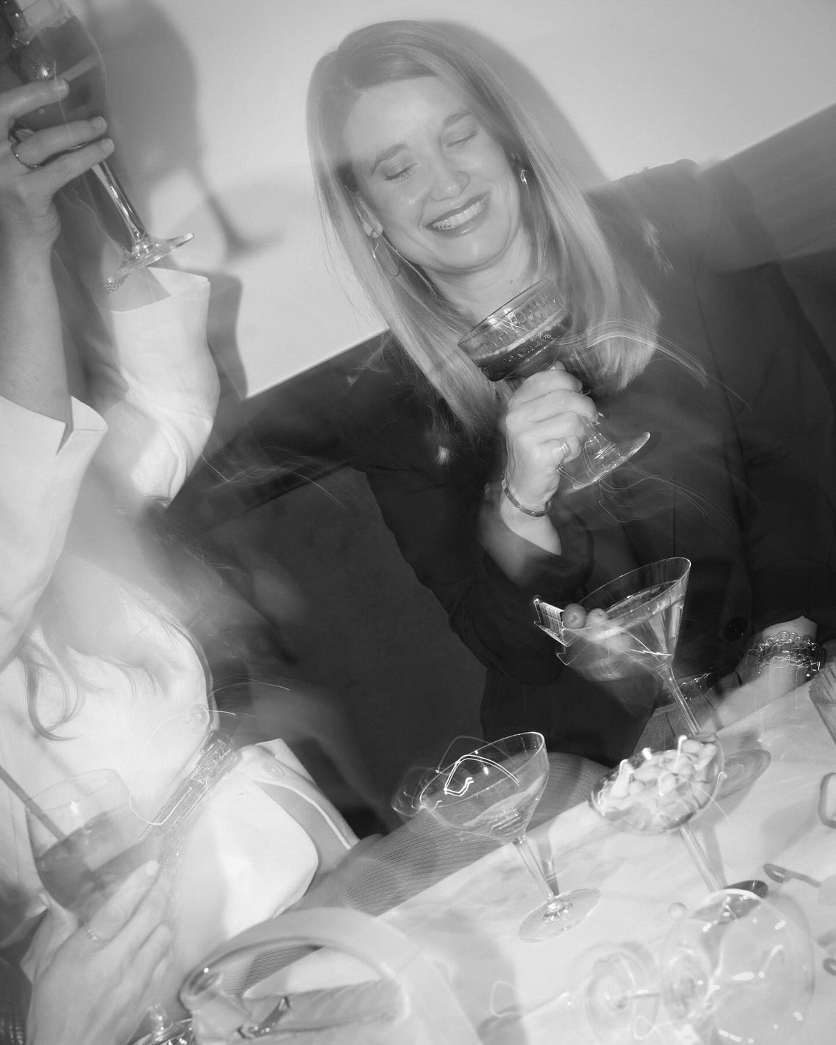 schwarz-weiße Frau, die lächelt und einen Cocktail trinkt